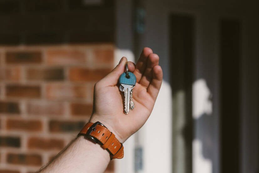 closeup-person-hand-holding-keys-with-blurred-background