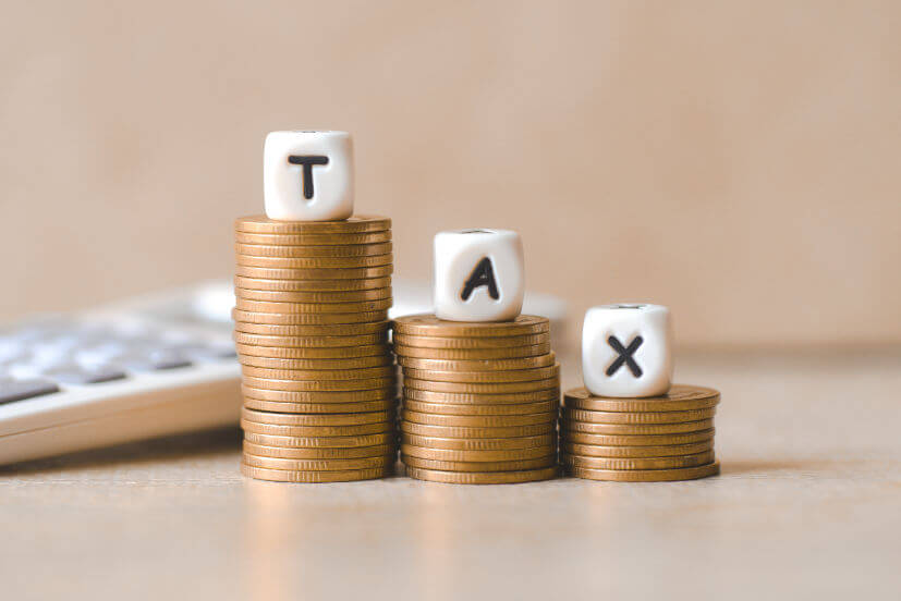 block-word-tax-money-calculator-wooden-background-tax-stacked-coins-financial-tax-concept